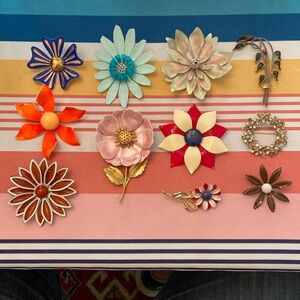 11 vintage flower pins. Unsigned. Good clasps. Enamels & rhinestones. Multicolor